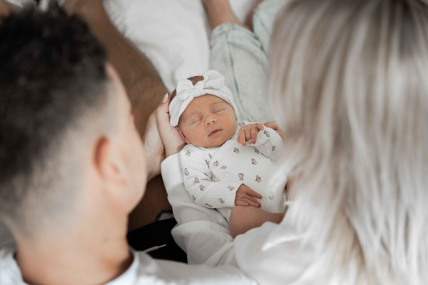 Vader en moeder kijken naar slapende baby