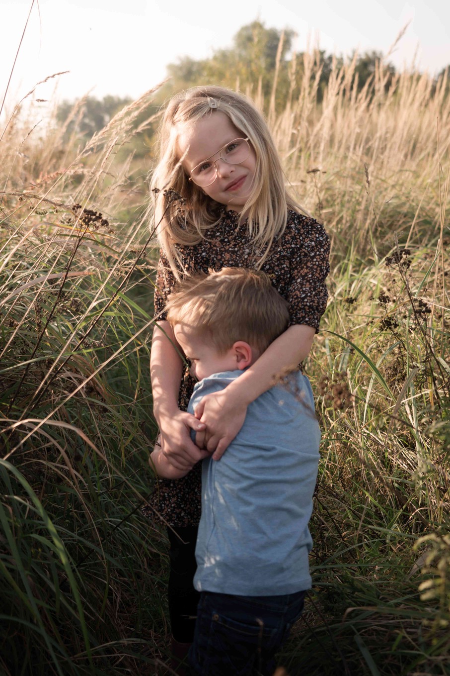 Zus en broertje staan in de natuur