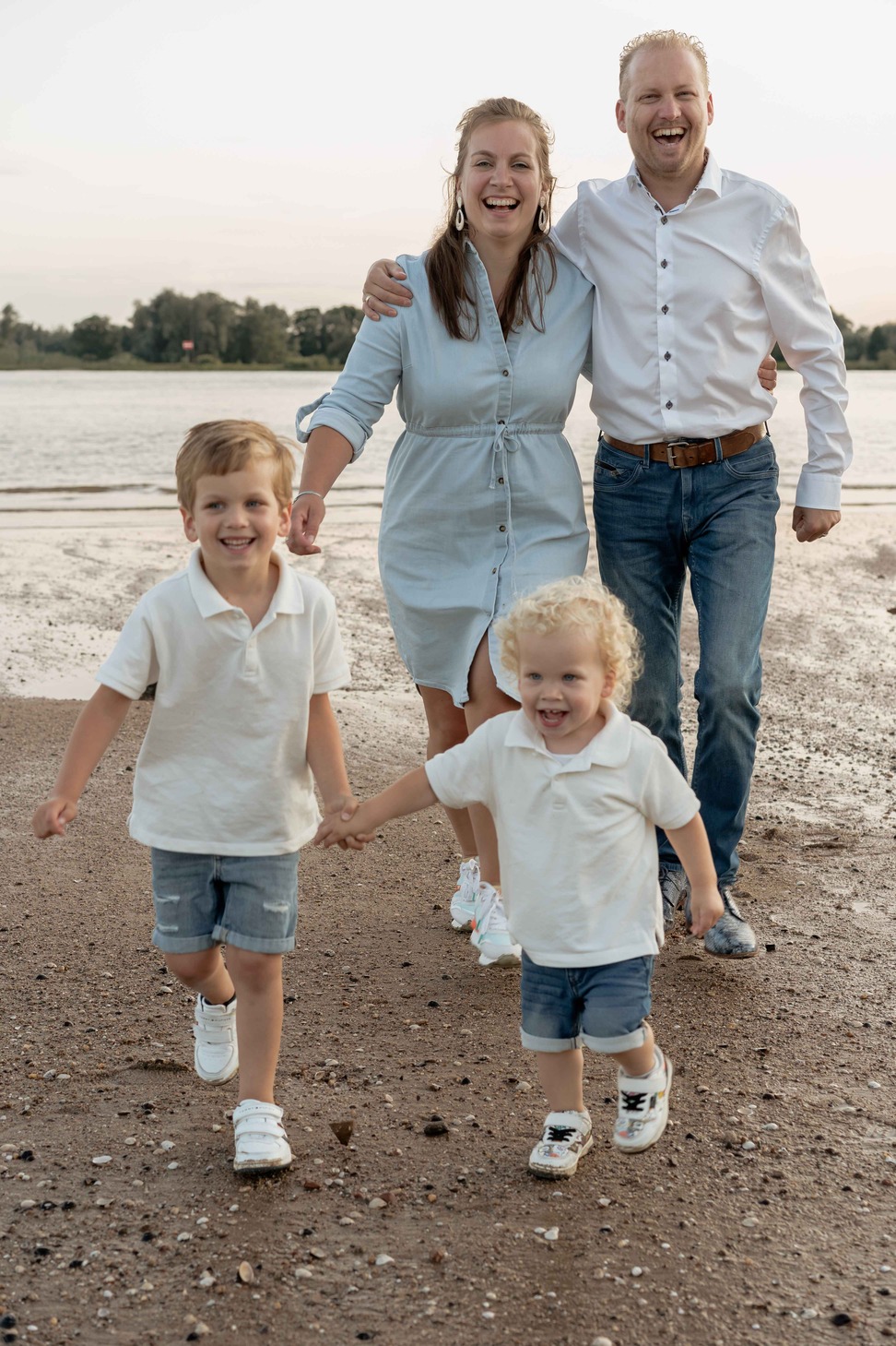 Vader en moeder en twee kinderen lopen nar de camera