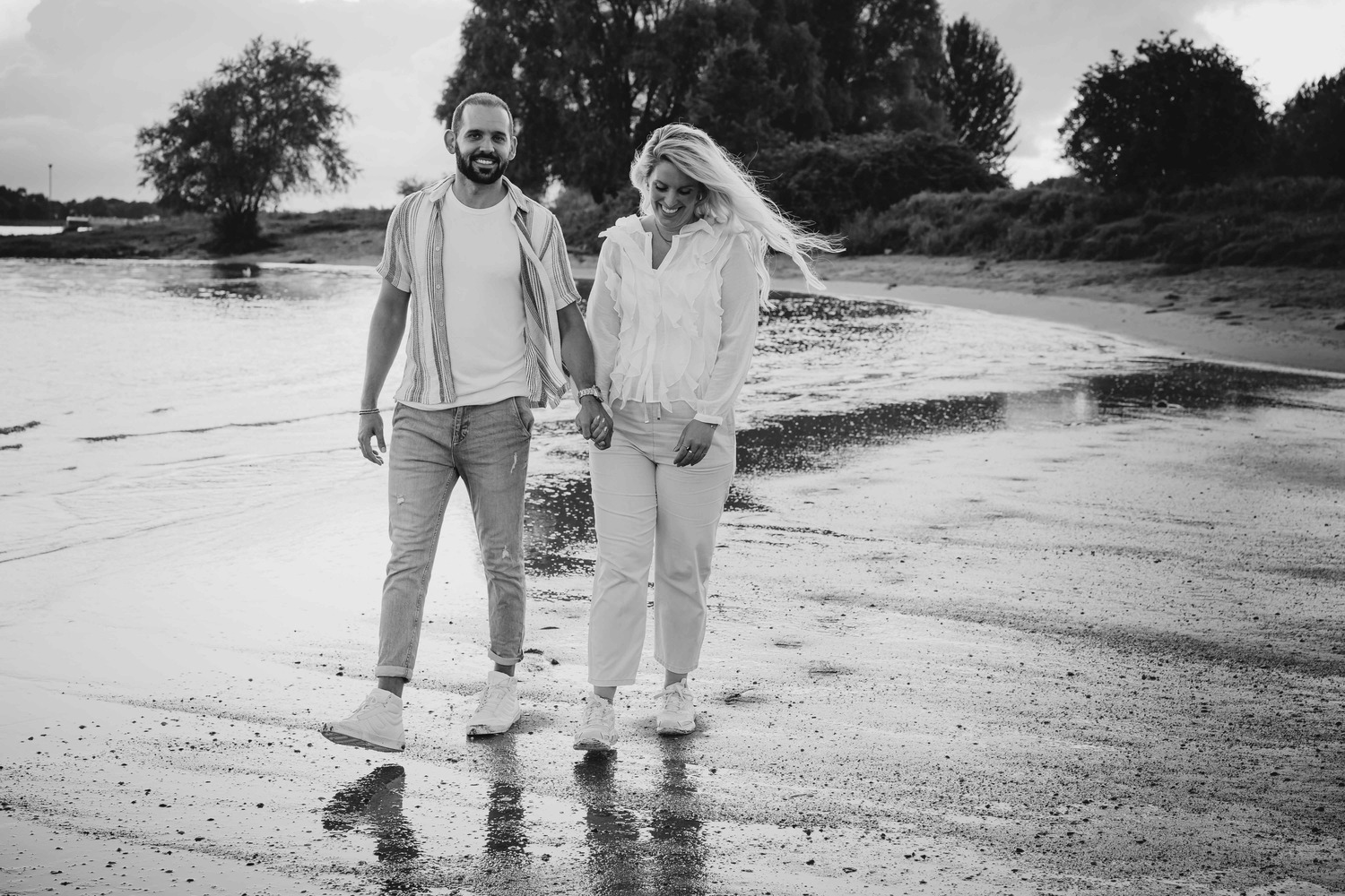 Man en vrouw lopen langs de waterlijn
