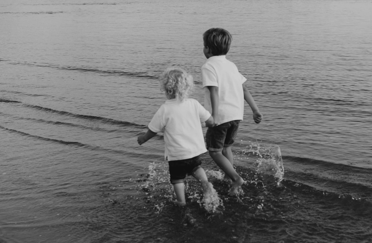 Twee broertjes rennen door het water