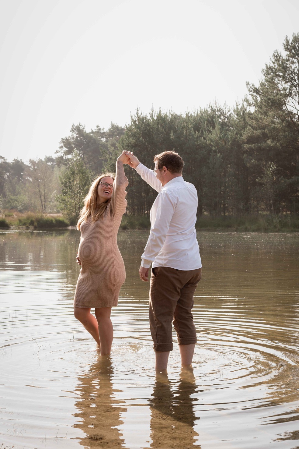 Man en zwangere vrouw dansen in water