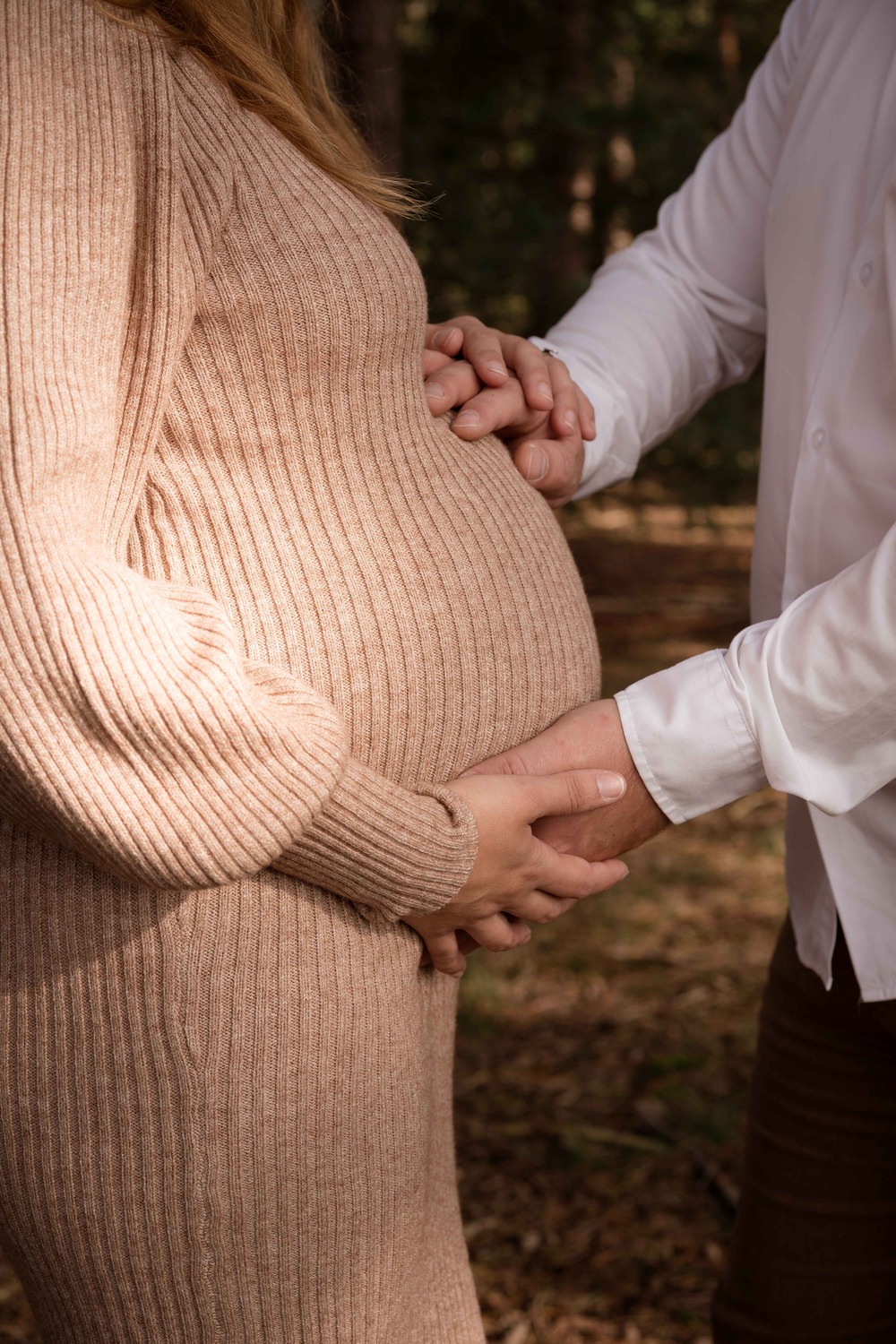 Man heeft handen op buik van zijn zwangere vrouw